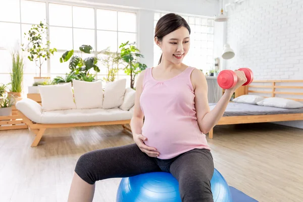Азиат Молодая Беременная Женщина Делает Упражнения Пилатесом Мяч Гантели Гостиной — стоковое фото