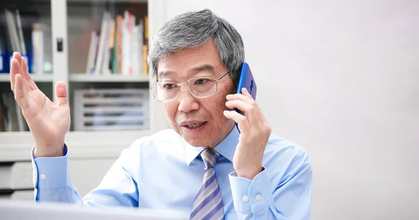 亚洲资深商人在办公室用智能手机讨论他的工作计划 — 图库照片