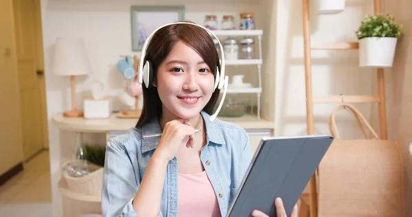 远程办公的概念 带着耳机的亚洲女人在家里通过网络摄像头和数字平板电脑参加一个视频会议 — 图库照片