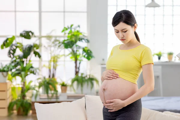 妊娠中の女性はリビングルームでうつ状態になり — ストック写真