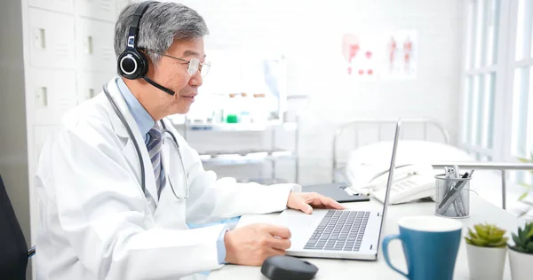 Teletıp Konsepti Asyalı Kıdemli Erkek Doktor Internette Hastanın Semptomlarını Dinliyor — Stok fotoğraf