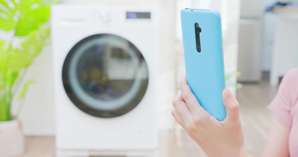 Woman use smartphone control washer — Stock Video