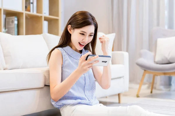 Aasialainen Nuori Nainen Pelata Mobiilipelejä Älypuhelimella Voittaa Nyrkki Ele Kotona — kuvapankkivalokuva