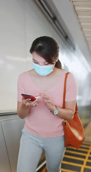 마스크를 아시아 여성은 지하철 역에서 에스컬레이터 이어폰으로 음악을 이어폰을 — 스톡 사진