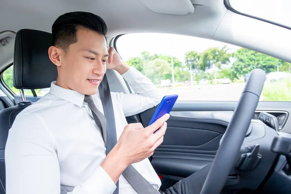 Asiatisk Mann Som Bruker Smarttelefon Mens Han Kjører Bil – stockfoto