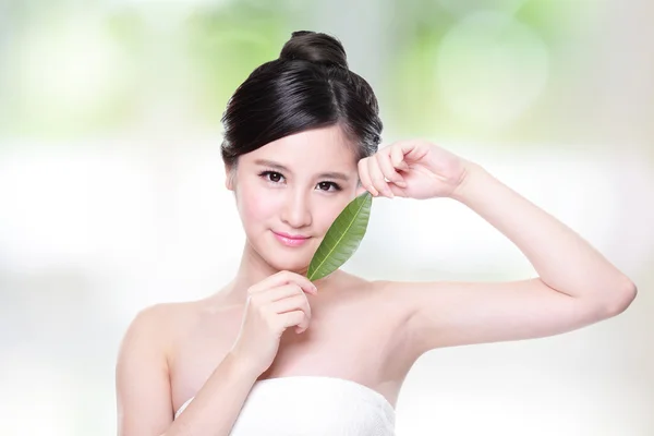 Mooie vrouw gezicht portret met groen blad — Stockfoto