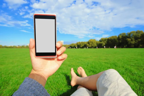 Man using smartphone in park — Stock Photo, Image