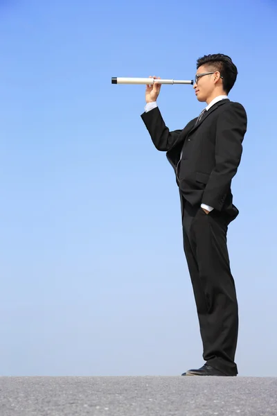 Businessman using telescope — Stock Photo, Image