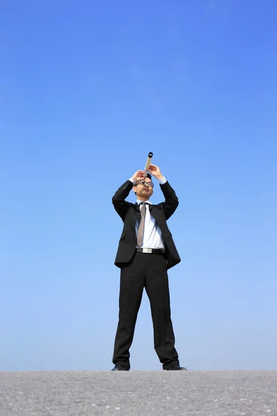 Businessman using telescope — Stock Photo, Image