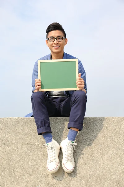 Hombre feliz sosteniendo pizarra — Foto de Stock