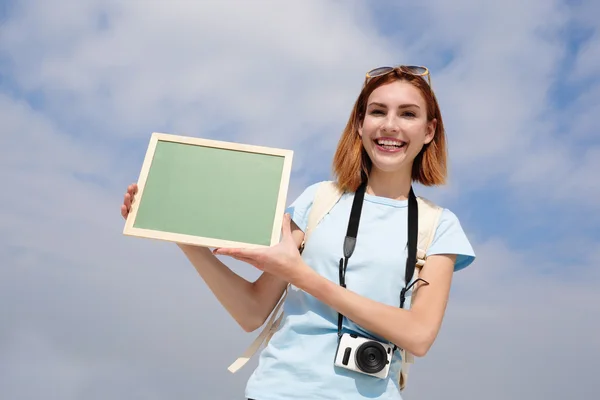 Woman showing empty chalkboard — Stock Photo, Image