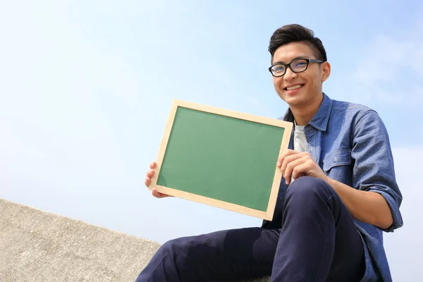 Homem feliz segurando quadro negro — Fotografia de Stock