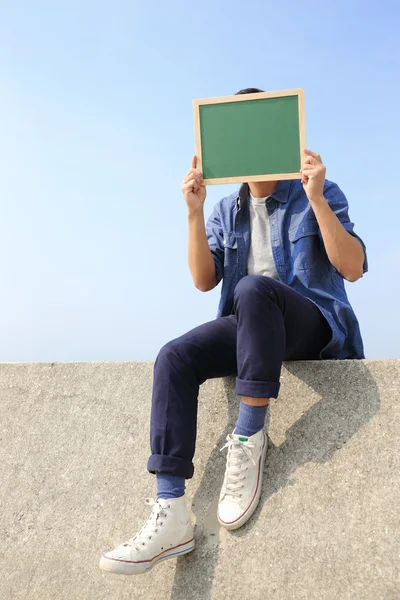 Hombre feliz sosteniendo pizarra — Foto de Stock