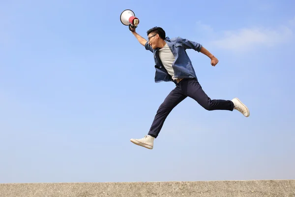 Man springen en schreeuwen megafoon — Stockfoto