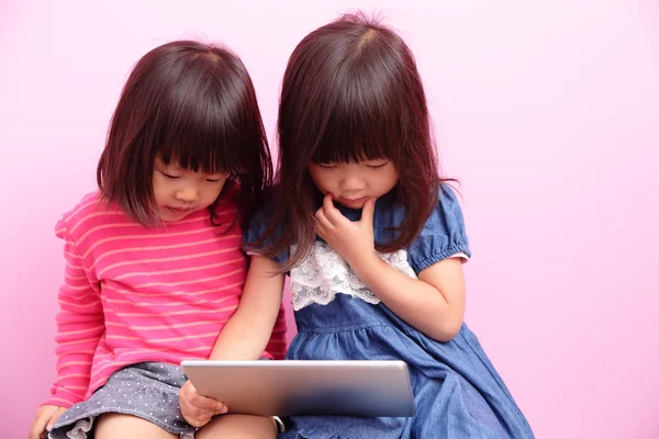 Счастливые девочки с планшетным компьютером — стоковое фото