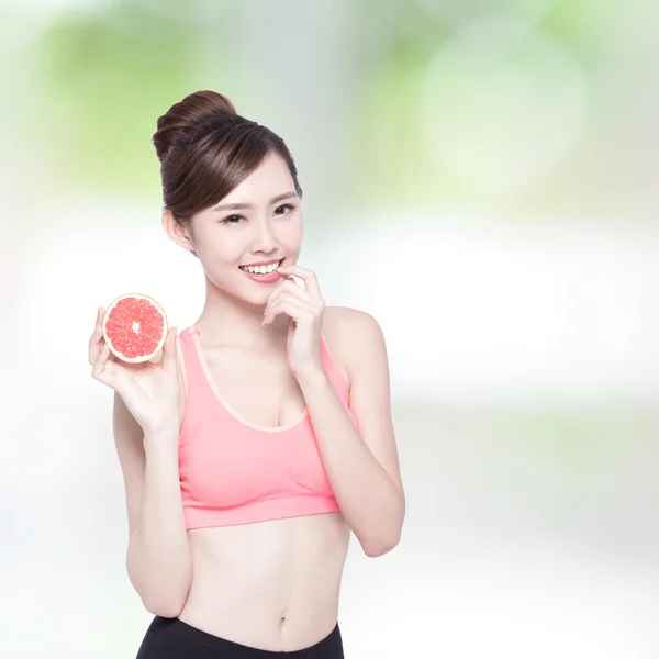 Женщина держит в руках грейпфрут — стоковое фото