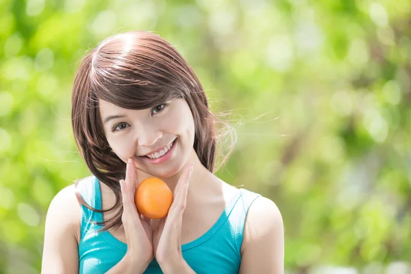 Jovem mulher segurando laranja — Fotografia de Stock