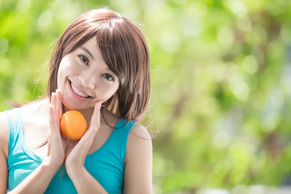 Jovem mulher segurando laranja — Fotografia de Stock