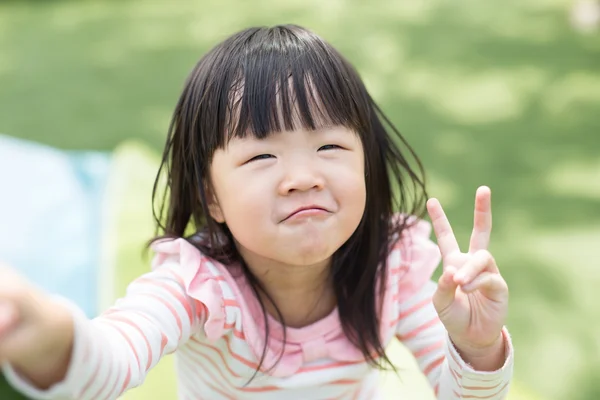 Girl smiling showing victory sign Stock Picture