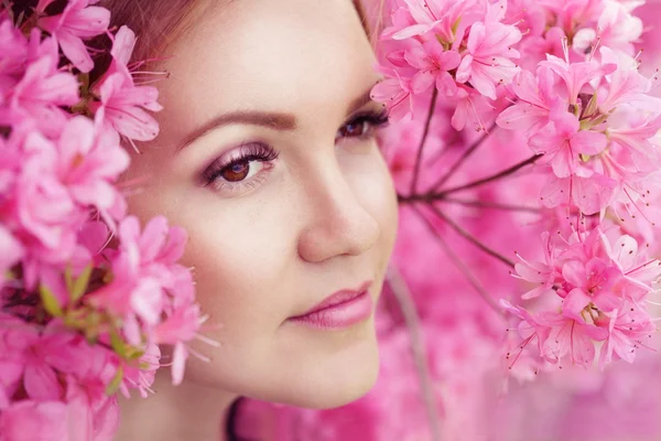 Primer plano retrato de hermosa joven hembra en rosa esponjoso arbusto de flores de primavera —  Fotos de Stock