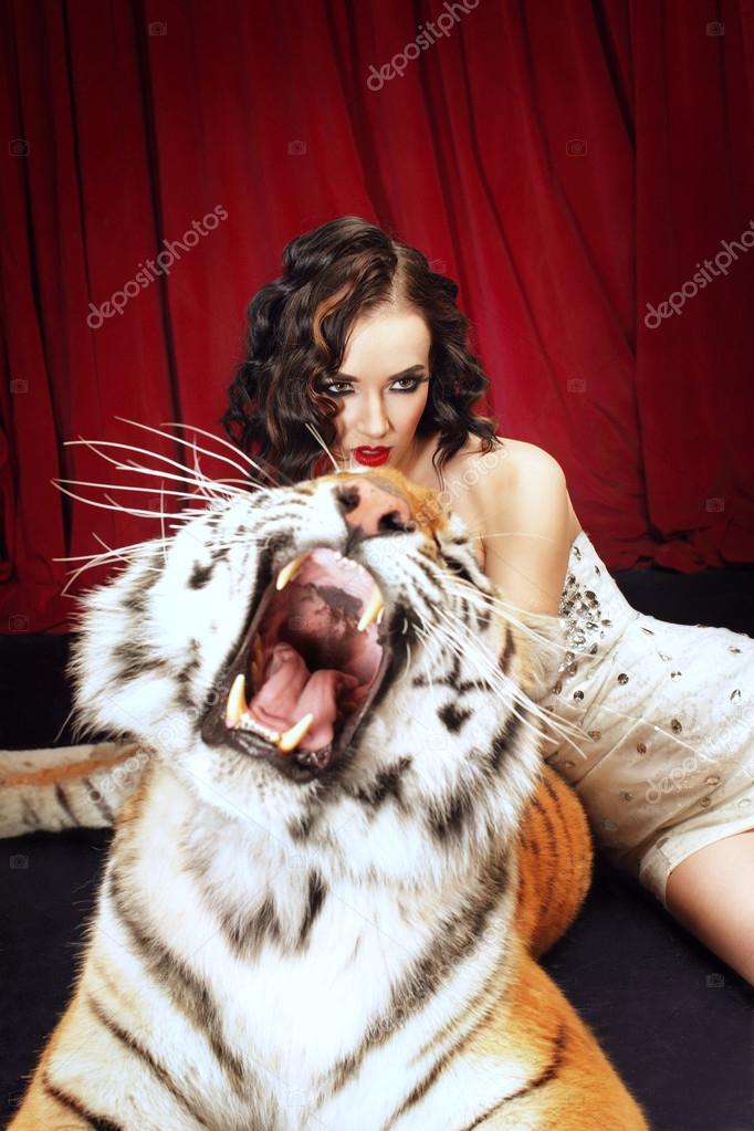 Real roaring tiger protects a beautiful brunette