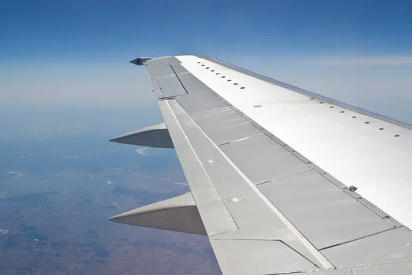 The wing of an airplane flying somewhere over the open spaces is a plot well known to all travelers.