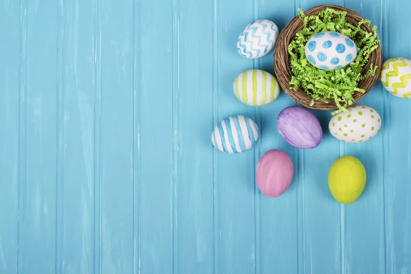 Easter eggs in nest on blue background — Stock Photo, Image
