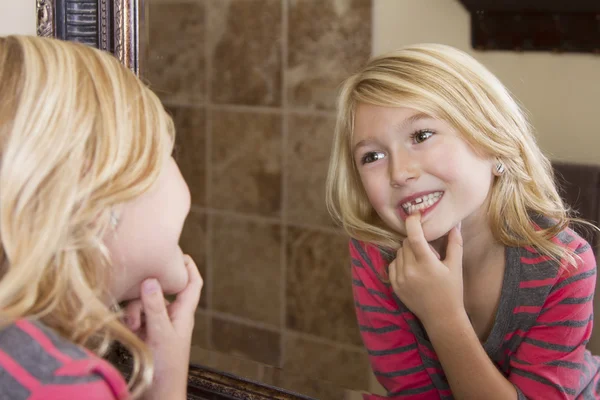 Enfant regardant dans le miroir à la dent avant manquante — Photo