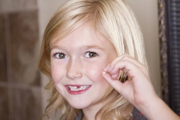 Child holding her front tooth — Stock Photo, Image