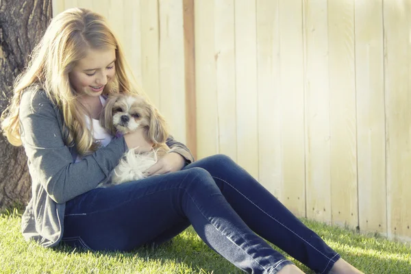 Teenage girl holding a small dog — Stock Photo, Image