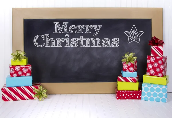 Christmas presents grouped around a chalkboard — Stock Photo, Image