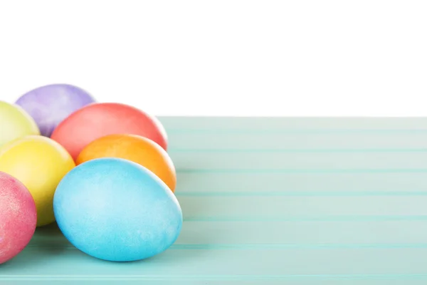 Dyed Easter eggs on a turquoise blue wooden panel — Stock Photo, Image