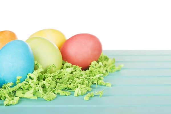 Dyed Easter eggs on green confetti — Stock Photo, Image