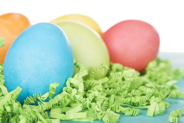 Dyed Easter eggs on green confetti — Stock Photo, Image