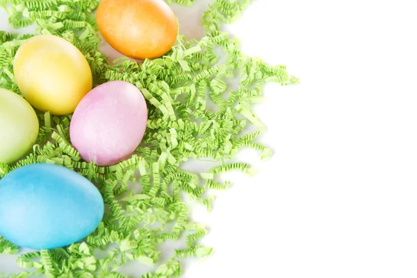 Dyed Easter eggs on green confetti — Stock Photo, Image