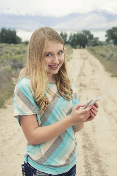国土の道を歩きながら携帯電話を使用して 10 代の少女 — ストック写真