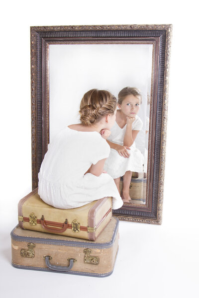 Child or young girl staring at herself in a mirror