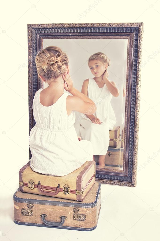 Child or young girl staring at herself in a mirror