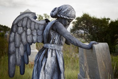 Girl wearing an angel costume in an old grave yard clipart