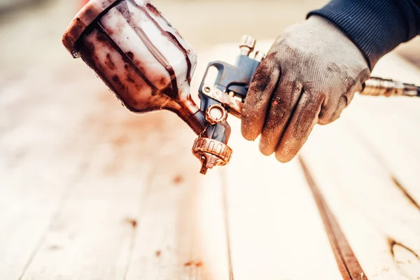 Primer plano de una pistola de pintura en aerosol y mano de trabajador — Foto de Stock