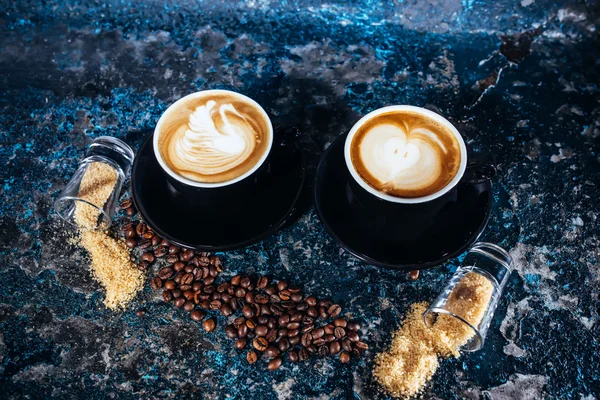 Latte sanat sıcak kahve ve kahve çekirdekleri arka planda — Stok fotoğraf