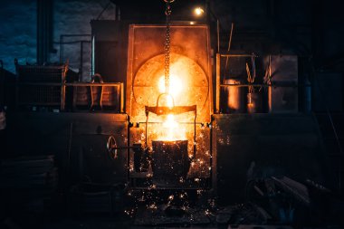 Smelting metal in a metallurgical plant. Liquid iron from metal ladle pouring in castings at factory clipart