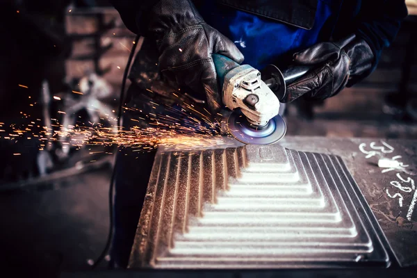 Molienda de rueda eléctrica en estructura de acero en fábrica industrial. trabajador de corte de acero — Foto de Stock