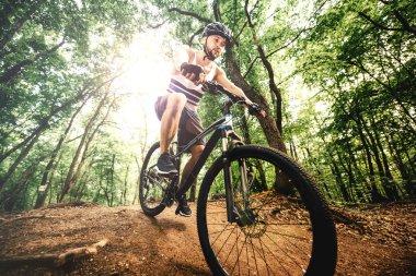 bisikletçi kask binme dağ bisikleti üzerinde kayalık orman iz ile bir