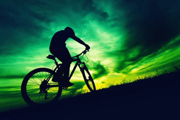 Silhouette di un ciclista contro cielo colorato al tramonto — Foto Stock