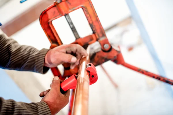 Industriearbeiter mit industriellem Kupferschneider im Sanitärbereich — Stockfoto