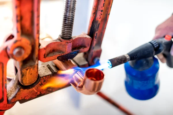 Trabajador industrial que utiliza antorcha de gas propano para soldar tuberías de cobre . — Foto de Stock