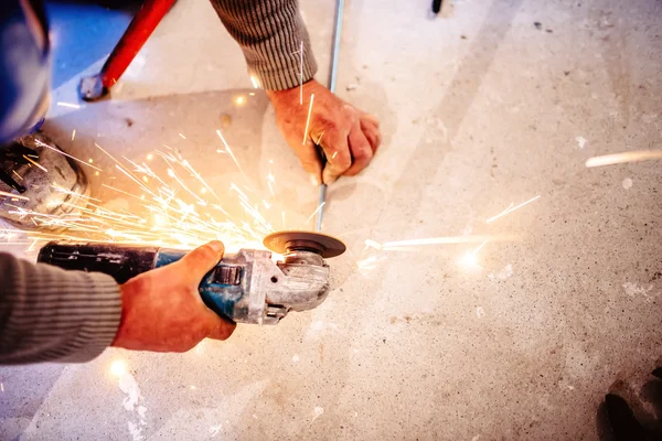 Werknemer snijden stalen balken met handmatige grinder — Stockfoto