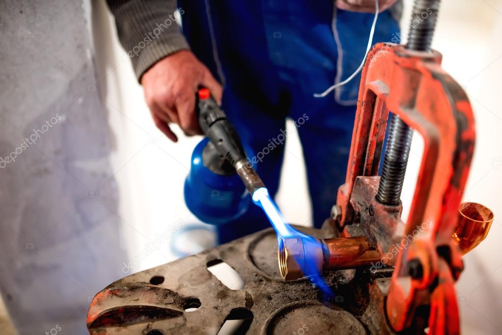 Worker, plumber using blowtorch for soldering copper fittings — Stock