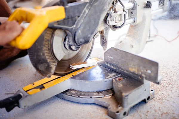 Worker using mitre saw for cutting wood parquet — Stock Photo, Image